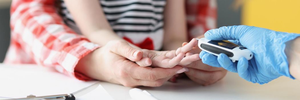 Close-up of doctor in laboratory taking blood of little girl thumb using lancet in clinic, standard procedure for checkup, analysis. Medicine, hospital, pediatrician appointment concept