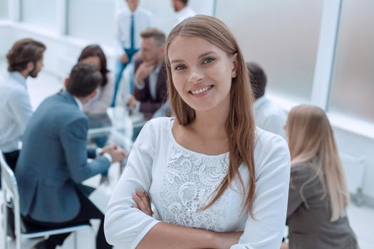 smiling young employee standing in business office. business concept