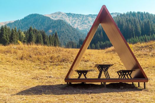 Modern gazebo on a tourist trail with a picturesque view of the summer mountains.