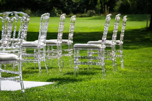 Festive plastic furniture at a wedding ceremony in beautiful green grass.