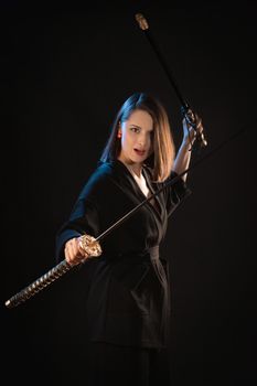 Fighting stance of a woman in a kimono with a katana and scabbard.