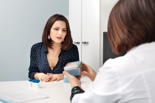 Woman patient looks skeptically at the doctor's proposed medication.