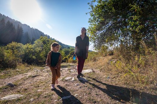 Woman with her daughter 5 years old on a hike in the mountains.