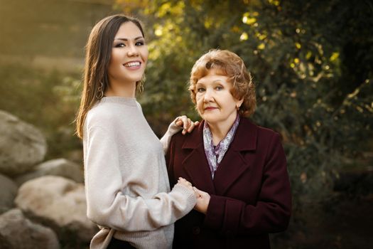 Happy mom with daughter holding hands outdoors in the forest. High quality photo