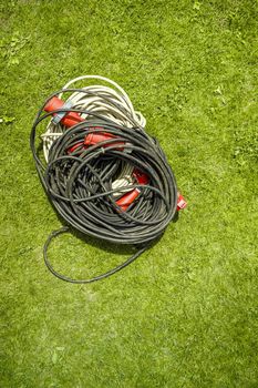 Power three phase wire extension cord for high voltage wires on grass with copy space.