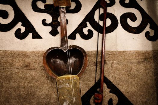 Musical instrument kobyz against the background of Kazakh patterns. High quality photo
