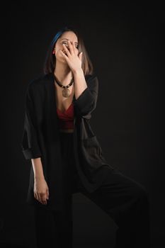 Woman in night clothes laughs emotionally covering her face with her hand.