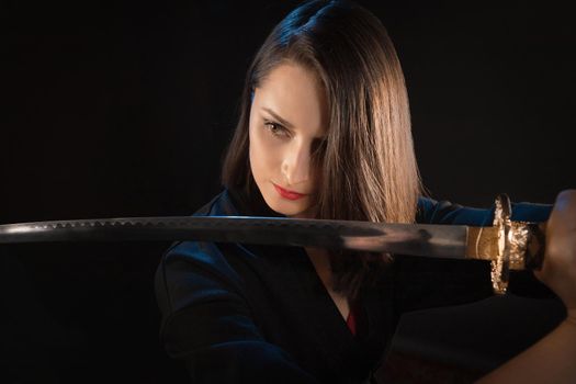 Young brunette warrior woman with katana sword.