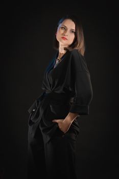 Studio fashion shoot in low key with a woman in black clothes.