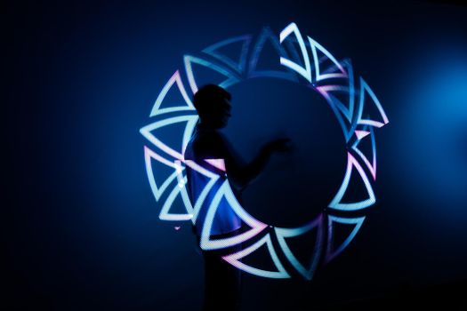 Night Light show of jugglers with LED sticks at the robot exhibition. Almaty, Kazakhstan - February 19, 2022