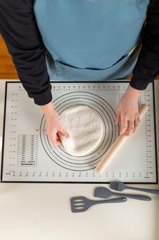 Top view of dough cooking process with kitchen baking mat, vertical copy space.