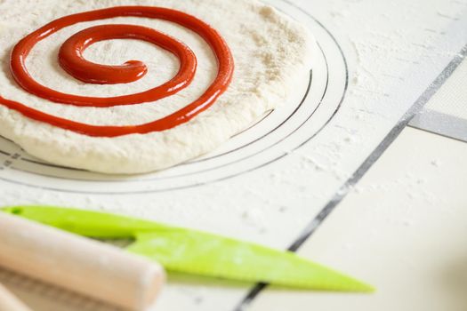 Berry jam spirally applied to rolled out dough for a sweet dessert roll.