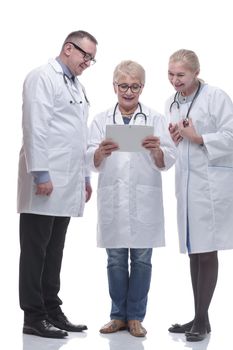 in full growth. group of smiling doctors with a digital tablet. isolated on a white background