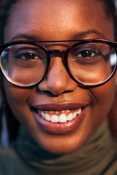 vertical close-up portrait of a young black woman with glasses smiling looking at the camera, concept of youth and happiness