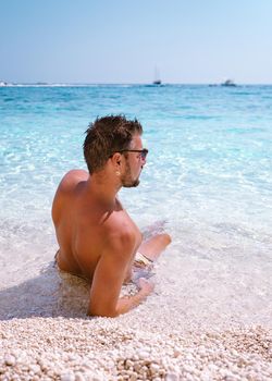 Golfo di Orosei Sardina, Men on the beach Sardinia Italy, young guy on vacation Sardinia Italy, man playing in the ocean with crystal clear blue water, . High quality photo