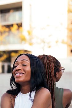 vertical portrait of a young black woman happy to be with her friend, concept of youth and friendship, copy space for text