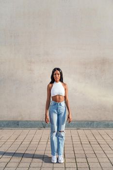 young black woman poses standing looking at the camera, concept of youth and racial diversity, copy space for text