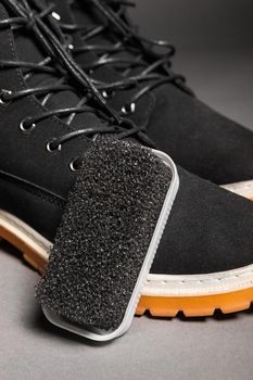 Black hard sponge next to suede black winter boots.