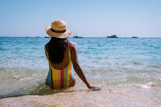 Golfo di Orosei Sardina, Asian women on the beach Sardinia Italy, a young girl on vacation Sardinia Italy, woman playing in the ocean with crystal clear blue water,