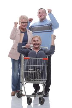 in full growth. a group of cheerful shoppers with a shopping cart . isolated on a white background