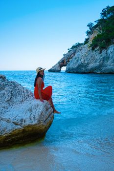 Golfo di Orosei Sardina, Asian women on the beach Sardinia Italy, a young girl on vacation Sardinia Italy, woman playing in the ocean with crystal clear blue water,