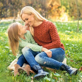 Happy smiling young caucasian mother and little daughter hugging each other outdoors. Happy family outdoor.