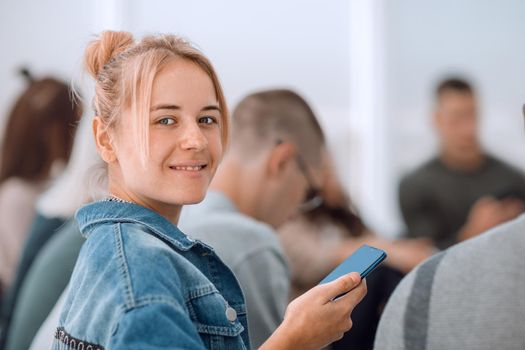 close up. casual young woman with smartphone looking at camera