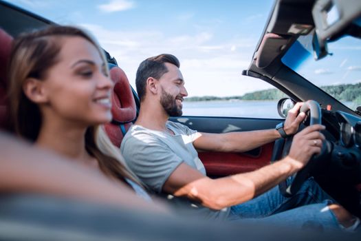 close up.smiling couple sitting in a convertible car.travel together