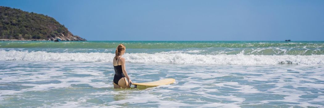 BANNER, LONG FORMAT Beautiful young woman ride wave. Sporty surfer woman surfing on the background of blue sky, clouds and transparent waves. Outdoor Active.