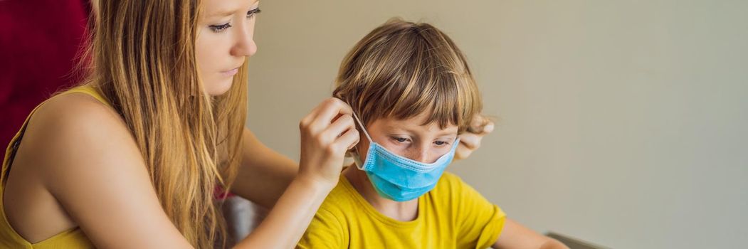 Boy studying online at home using a tablet. Mom helps him learn. Mom and son in medical masks to protect against coronovirus. Studying during quarantine. Global pandemic covid19 virus. BANNER, LONG FORMAT