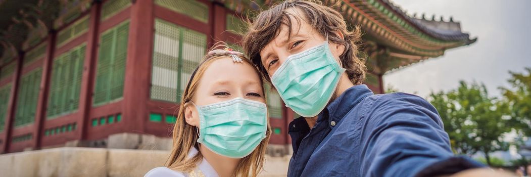 Young couple of spouses in medical mask. Bride and groom, a husband and wife, boyfriend and girlfriend spend time in Korea. Holidays in Korea. Honeymoon, travel to Korea concept Tourists fear the 2019-ncov virus. Medical masked tourists. BANNER, LONG FORMAT