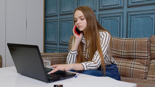 Smiling young business woman professional consultant talking, on mobile phone, using laptop sit at home office in living room, customer make call confirming online website shopping order delivery