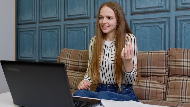 Business people displeased emotions lifestyle concept. Angry irritated young female woman consultant working on laptop computer spreading hands screaming swearing while making video call with customer