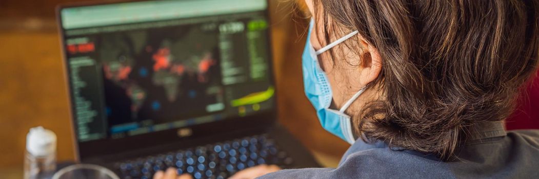 Coronavirus. A man looks at a map of the coronovirus. Working from home wearing protective mask. quarantine for coronavirus wearing protective mask. Working from home. BANNER, LONG FORMAT