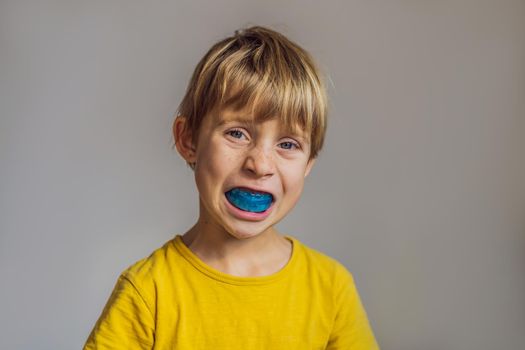 Six-year old boy shows myofunctional trainer. Helps equalize the growing teeth and correct bite, develop mouth breathing habit. Corrects the position of the tongue.