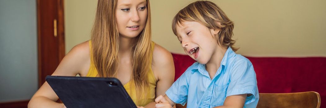 A boy studying online at home using a tablet. Mom helps him learn. Studying during quarantine. Global pandemic covid19 virus. BANNER, LONG FORMAT