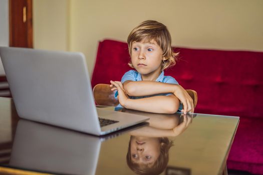 Boy studying online at home using laptop. Studying during quarantine. Global pandemic covid19 virus.