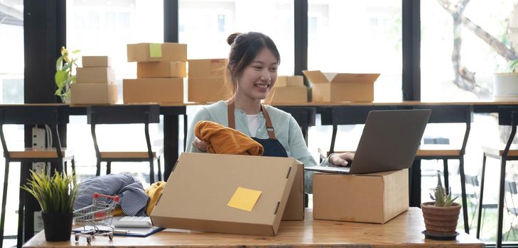 Starting small businesses SME owners female entrepreneurs check online orders to prepare to pack the boxes, sell to customers, sme business ideas online..