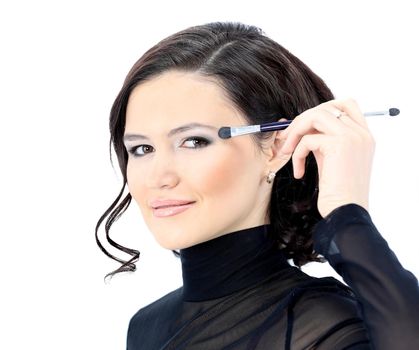 Beautiful woman with makeup brush near her face - isolated on white