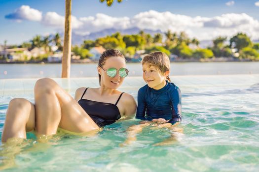 Luxury resort swimming pool. Happy family tourists relaxing in holiday retreat on summer travel vacation enjoying ocean background.