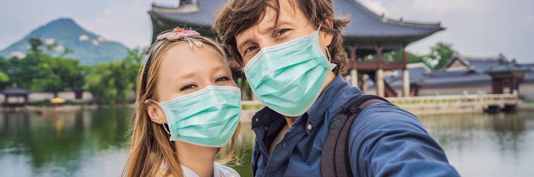 Young couple of spouses in medical mask. Bride and groom, a husband and wife, boyfriend and girlfriend spend time in Korea. Holidays in Korea. Honeymoon, travel to Korea concept Tourists fear the 2019-ncov virus. Medical masked tourists BANNER, LONG FORMAT