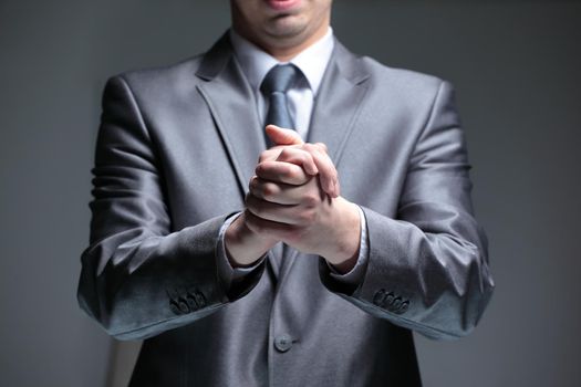 close up.businessman folded his hands .isolated on black background.