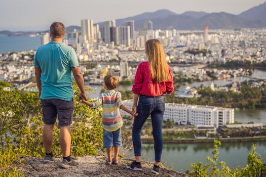 Happy family tourists on the background of Nha Trang city. Travel to Vietnam with kids Concept.