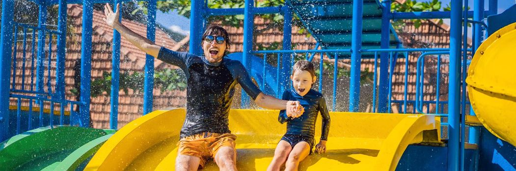 Father and son on a water slide in the water park. BANNER, LONG FORMAT