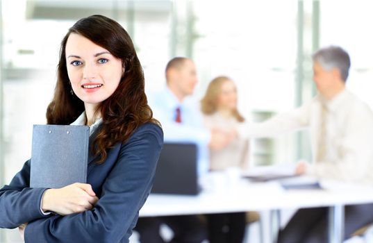 confident business woman with team behind her