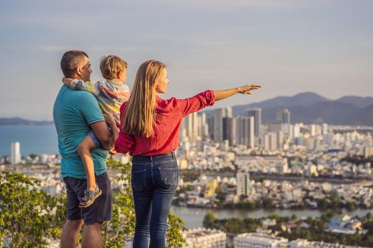 Happy family tourists on the background of Nha Trang city. Travel to Vietnam with kids Concept.