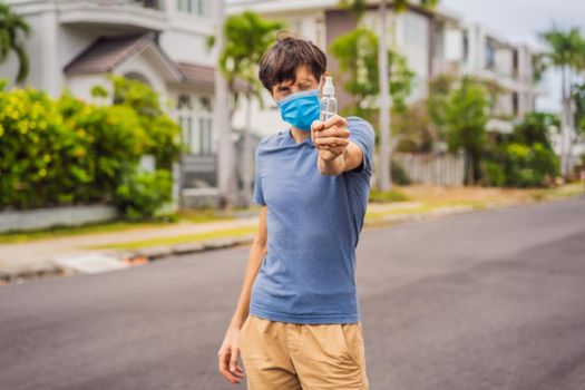 Man in a small town in a medical mask uses a sanitizer because of a coronovirus epidemic.