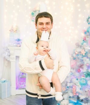 father and son standing next to a Christmas tree.happy fatherhood