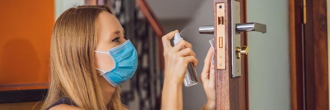 Woman hand is applying sanitizer on the door handle. Cleaning door handle with alcohol spray for Covid-19 Coronavirus prevention. disinfecting the door handle by spraying alcohol. BANNER, LONG FORMAT