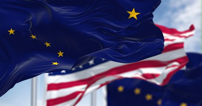 The flags of the Alaska state and United States waving in the wind. Democracy and independence. US state flag.